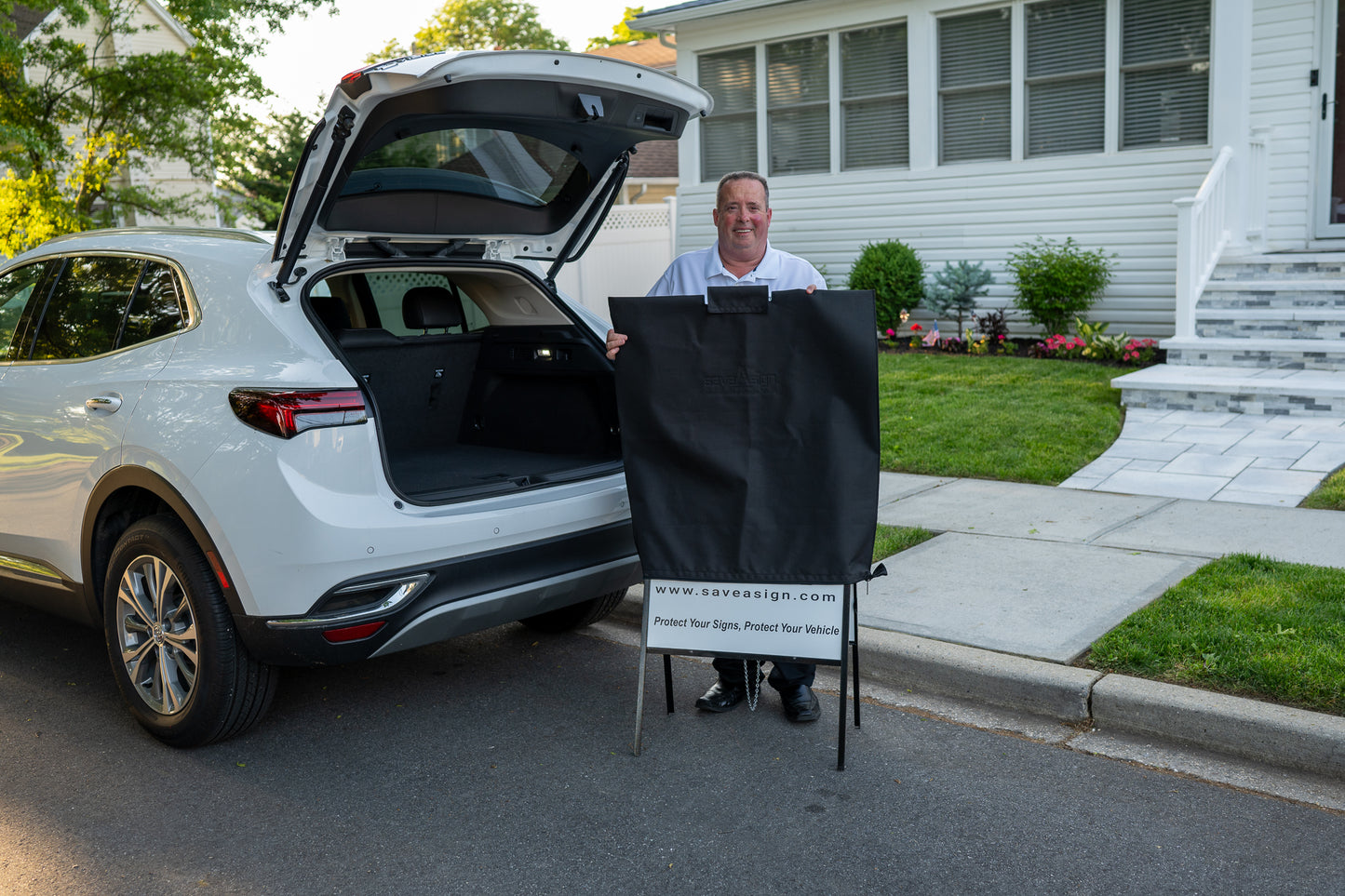 Smiling man demonstrating how easy it is to use a saveAsign™ real estate sign cover 